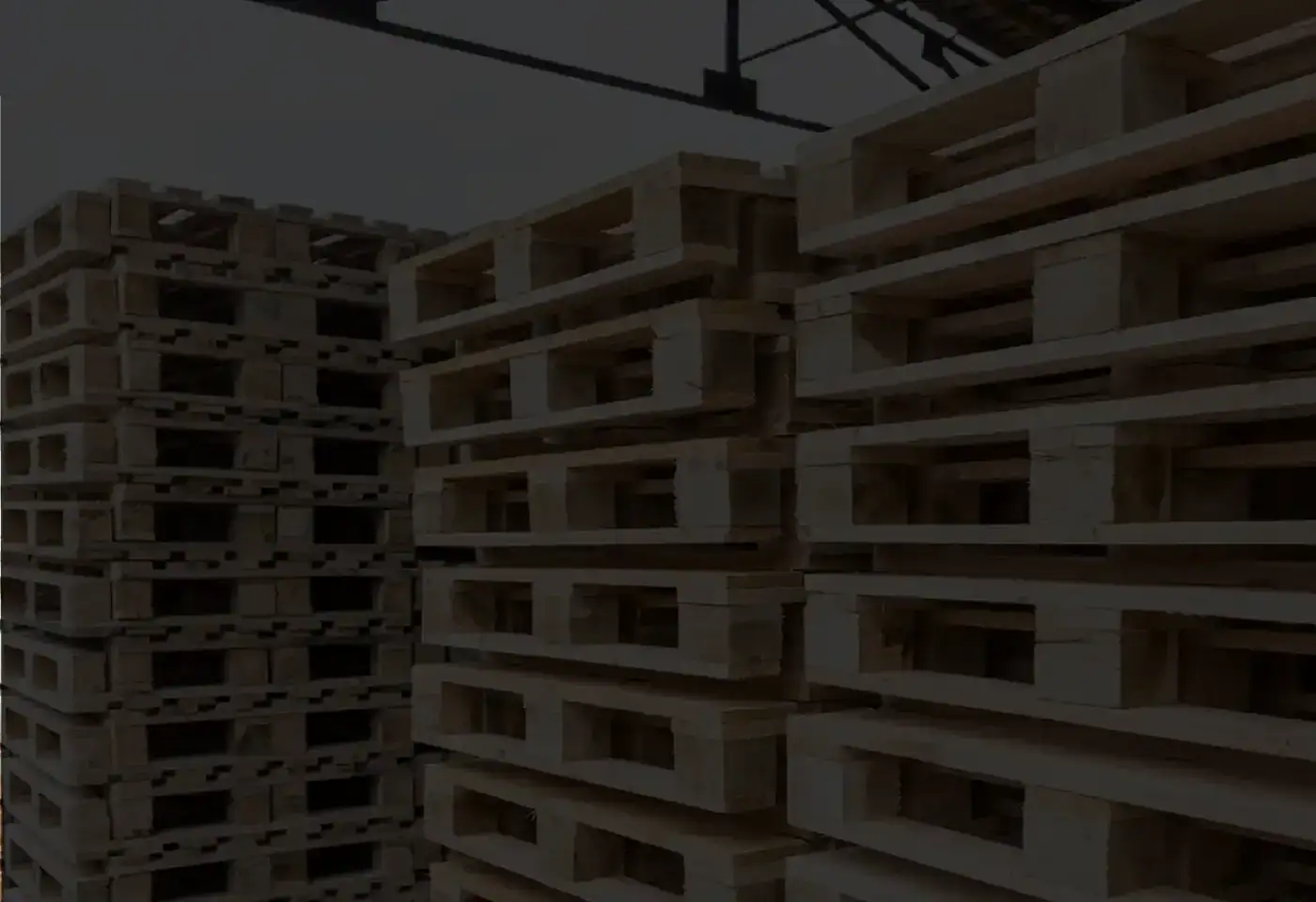 Pallets de madera nuevos y usados apilados en almacén