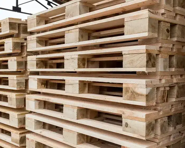Pallets de madera de medida estándar apilados en almacén